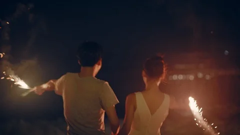 Couple let off fireworks on the beach Stock Footage 125412093