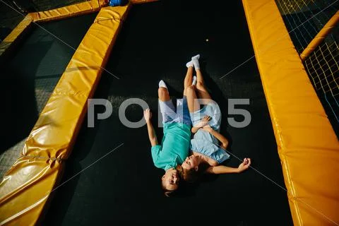 Couple lie on trampoline in the park Stock Photos