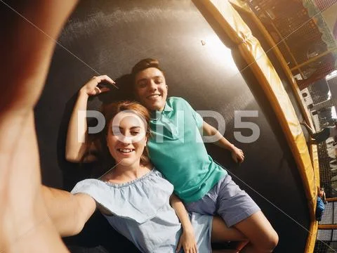 Couple lie on trampoline in the park Stock Photos