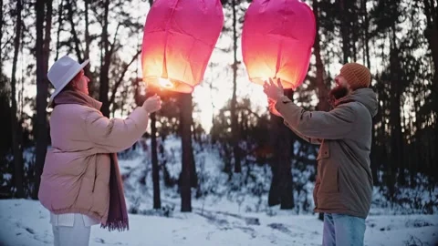Couple light sky lantern and hug in the woods in winter, celebrating valentines Stock Footage 169503611