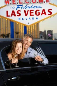 Couple In Limousine With Champagne Flutes By Welcome To Las Vegas Sign Stock Photos