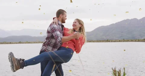 Couple linking arms and dancing at mountain lake, dipping, spinning, embracing Stock Footage 329924658