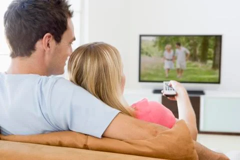 Couple in living room watching television Stock Photos
