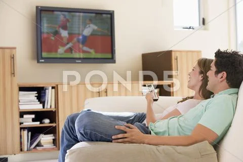 Couple in living room watching television Stock-Fotos