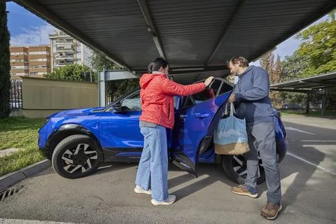 Couple loading items into car while preparing for trip Stock Photos
