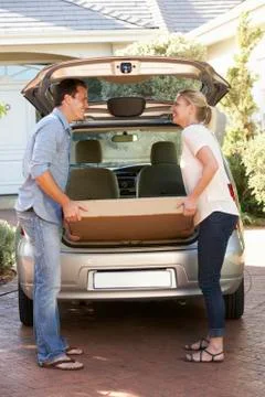 Couple Loading Large Package Into Back Of Car Stockfoto's
