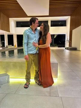 A couple look at each other while smiling in the lobby of a hotel Stock Photos