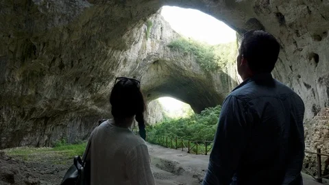 Couple looking at a big cave in the mountains Stock-Footage 112935815
