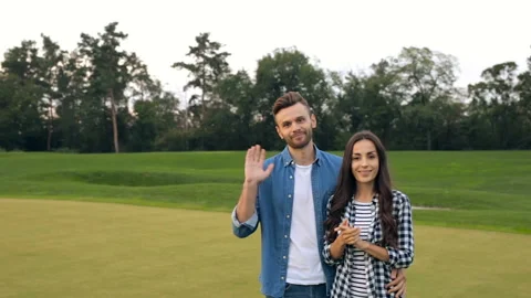 Couple looking at camera, doing good bye gesture and go away.  Stock Footage 95717171