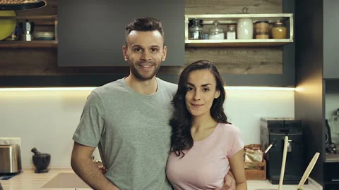 Couple looking at camera, smiling and doing bye bye sign. Video stock 100421358