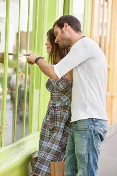 Couple looking at the display window of a store, Paris, Ile-de-France, France Stock Photos