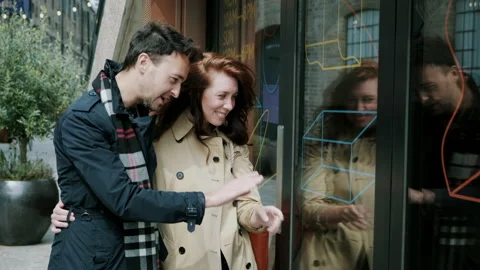 Couple looking at display window while talking and smiling Video stock 130599166