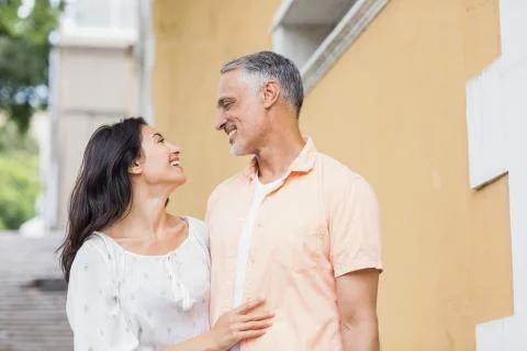 Couple looking each other while standing against building Fotos de archivo