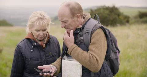 Couple looking at gps device in field Stock Footage 59899614