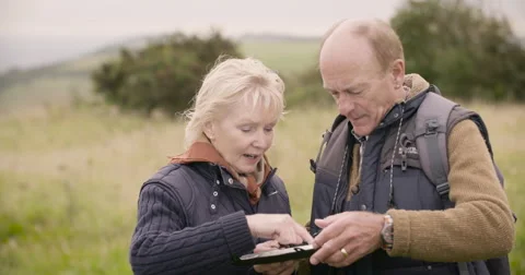 Couple looking at gps device in field Stock Footage 59899618