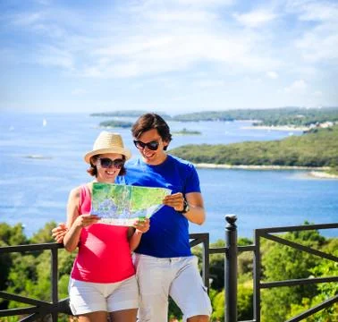 Couple Looking at Map by the Sea Stock Photos
