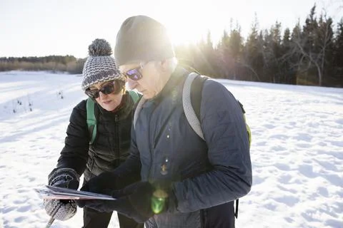 Couple looking at map on winter hike Fotos Stock