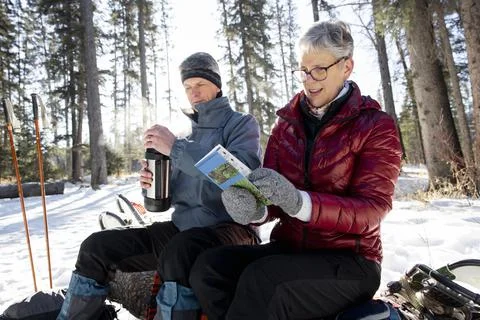 Couple looking at map on winter hike Fotos Stock