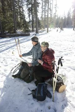 Couple looking at map on winter hike Fotos Stock