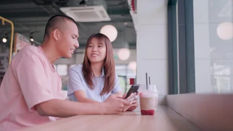 Couple looking at mobile phone while talking lovingly and expressing their love  Stock Footage 265230077