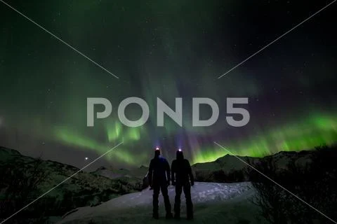 Couple looking the northern lights in the wild Stock Photos