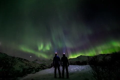 Couple looking the northern lights in the wild Stock Photos