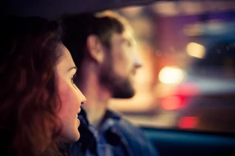 Couple looking out car window at night Stock Photos