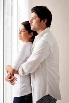 Couple looking out of window Stock Photos