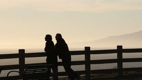 Couple looking at sunset with mountains in the background Video stock 166805434