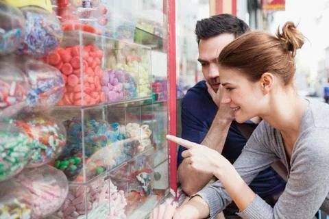 Couple looking at sweets in a window display 写真素材