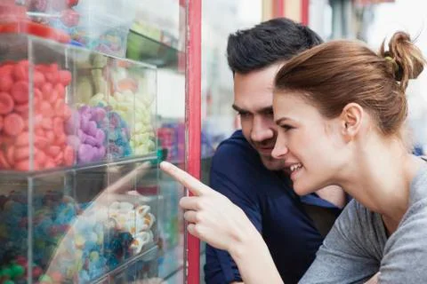 Couple looking at sweets in a window display 写真素材