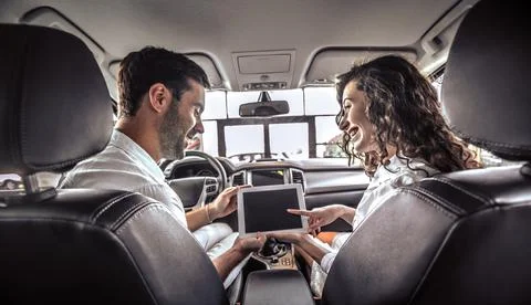 Couple is looking on tablet. The are looking options of brandnew car Stock Photos