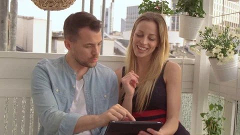 Couple looking at a Tablet on a balcony Stock Footage 111255074