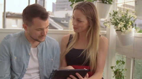 Couple looking at a Tablet on a balcony Video stock 111255086