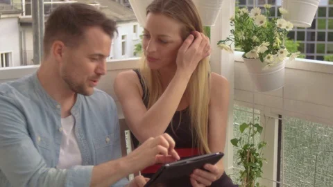 Couple looking at a Tablet on a balcony Stock Footage 111255148