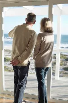 Couple looking through a window Stock Photos