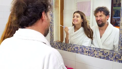 Couple looking white teeth after washing in front of mirror 4K slow motion Stock Footage 77512532
