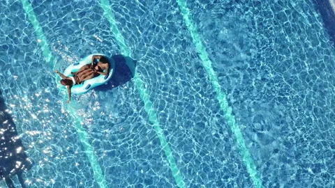 Couple Lounging on Inflatables in Pool Overhead Aerial, Jamaica Video stock 162766085