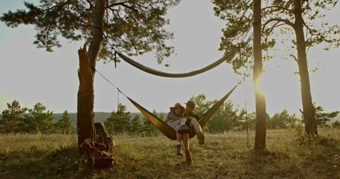 A couple in love are hugging while lying in a hammock in nature. Stock Footage 264488424