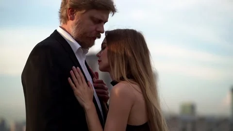 Couple in love: a bearded man in a jacket holds the hand of one woman, who 库存影片 134842739
