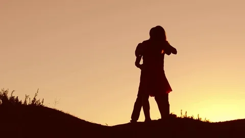 Couple in love dancing silhouette at sunset and kissing. Loving man and woman Stock Footage 78923053