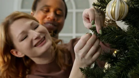 A couple in love decorates a fluffy tree together Stock Footage 166603069