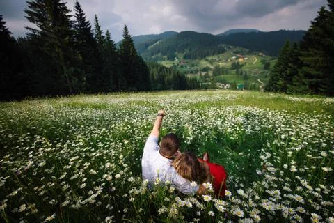Couple in love is enjoying the landscape view of the charming sunny mountains Stock Photos