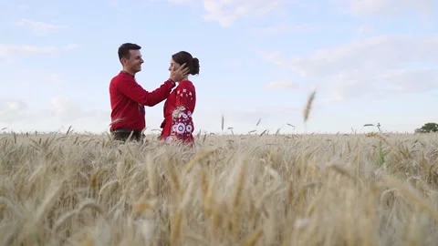Couple in love hugging at sunset in wheat. Red clothing. Slow motion Stock Footage 205889084