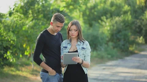 Couple in love looking at the photos on the tablet Stock Footage 55100343