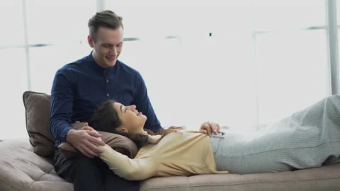 Couple in love lying on sofa talking  together on window Stock Footage 158754224