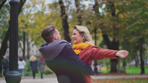 A couple in love or a married couple coal together in the park, a man holding up Stock Footage 143646653