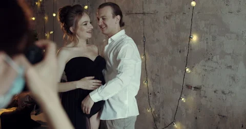 Couple in love pose and have a photo shoot with the photographer in their house Stock Footage 143873853