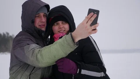 Couple in love posing on a camera in the winter, around a frozen lake, 4k Stock Footage 71315562