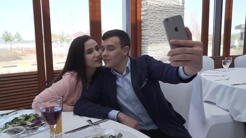 Couple in love at restaurant making selfie on iPhone stock footage video Stock Footage